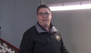 John-Moser-Bonfol-agriculture John Moser mit schwarzer Jacke in seinem Hühnerstall in Bonfol