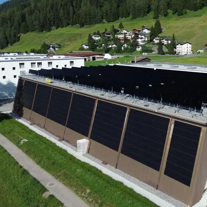 Aufnahme der neuen Sporthalle Färbi in Davos mit der Solaranlage an der Fassade und auf dem Dach